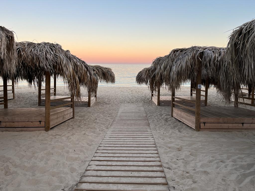 Balinese beds on Makronissos Beach at sunset