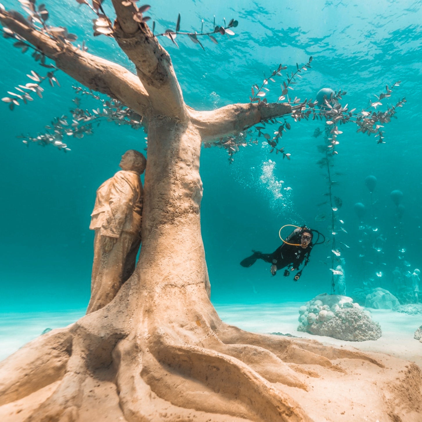 Person doing scuba diving next to a sculpture at MUSAN in Ayia Napa